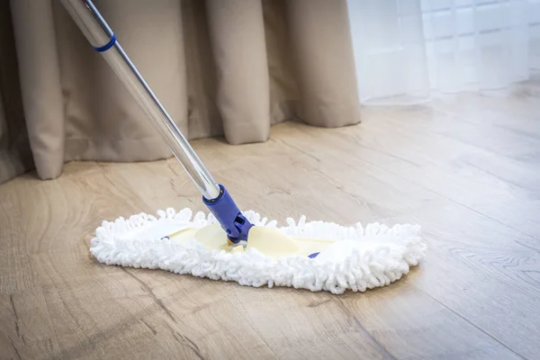 Fregona blanca moderna limpieza de un suelo de madera — Foto de Stock