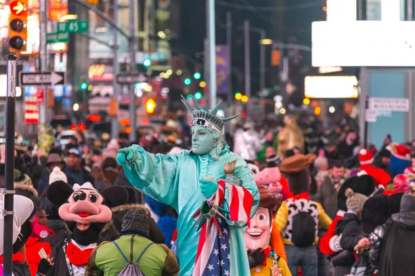 Times Square, New York - 18 DICEMBRE 2016: Vista notturna della via Times Square con artisti di strada vestiti da personaggi immaginari e Statua della Libertà — Foto Stock