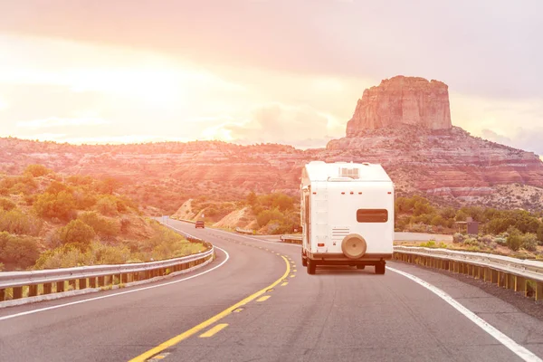 Viaje por carretera en coche autocaravana con fondo de montañas y destello de luz naranja brillante —  Fotos de Stock