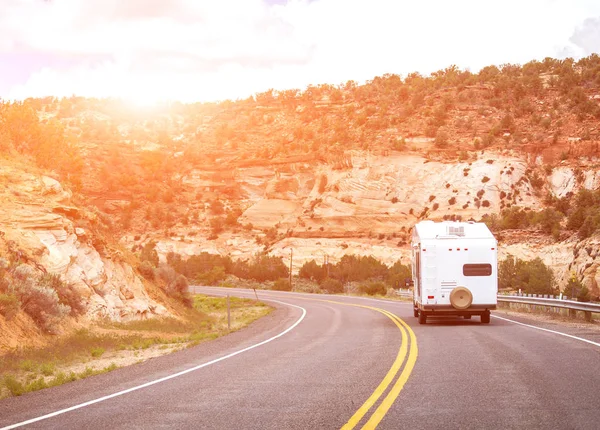 Viaje por carretera en coche autocaravana con fondo de montañas y destello de luz naranja brillante —  Fotos de Stock
