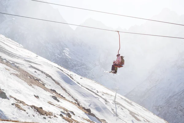 DOMBAI, RUSSIA - JANUARY 3, 2014: People are lifting on open lft high up in Caucasus mountains — Stock Photo, Image