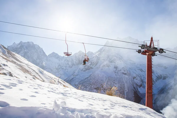 DOMBAI, RUSSIA - JANUARY 3, 2014: People are lifting on open lft high up in Caucasus mountains — Stock Photo, Image