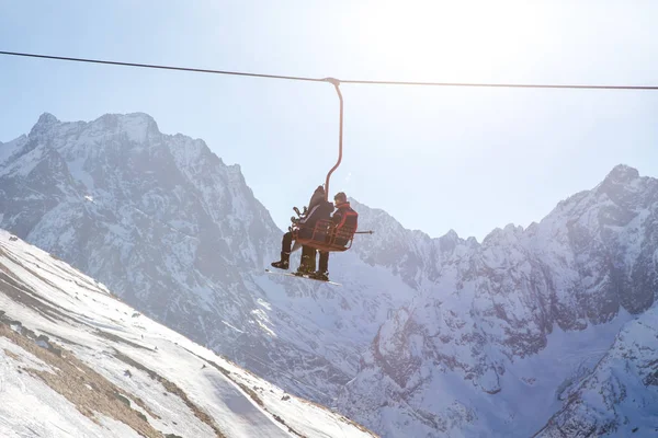 DOMBAI, RUSSIA - JANUARY 3, 2014: People are lifting on open lft high up in Caucasus mountains — Stock Photo, Image