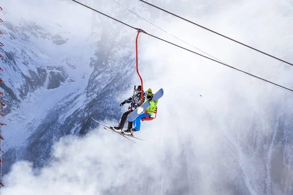 DOMBAI, RUSSIA - JANUARY 3, 2014: People are lifting on open lft high up in Caucasus mountains — Stock Photo, Image