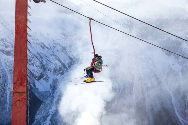 Dombai, Ryssland-3 januari 2014: människor lyfter på öppna lft högt upp i Kaukasus berg — Stockfoto