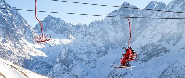Dombai, Ryssland-3 januari 2014: människor lyfter på öppna lft högt upp i Kaukasus berg — Stockfoto