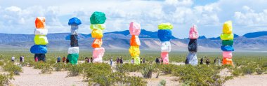 Las Vegas, Nevada, ABD - 12 Mayıs 2019: Las Vegas şehri yakınlarındaki Seven Magic Mountains sanat enstalasyonu. Neon renkli kayalardan yapılmış sütunlar çorak çöl arka plan ve mavi gökyüzüne karşı durmak.
