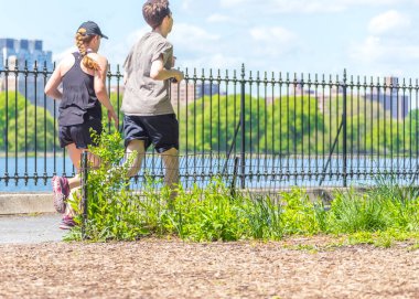 New York, ABD-15 Mayıs, 2019: Jogger New York 'ta Central Park rezervuar boyunca çalışan. Central Park, yıl boyunca aktif insanlarla doludur..