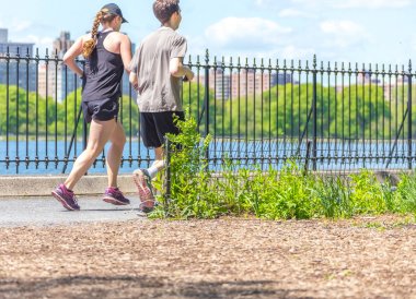New York, ABD-15 Mayıs, 2019: Jogger New York 'ta Central Park rezervuar boyunca çalışan. Central Park, yıl boyunca aktif insanlarla doludur..