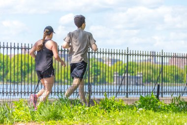 New York, ABD-15 Mayıs, 2019: Jogger New York 'ta Central Park rezervuar boyunca çalışan. Central Park, yıl boyunca aktif insanlarla doludur..