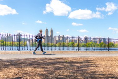 New York, ABD-15 Mayıs, 2019: Jogger New York 'ta Central Park rezervuar boyunca çalışan. Central Park, yıl boyunca aktif insanlarla doludur..