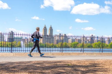 New York, ABD-15 Mayıs, 2019: Jogger New York 'ta Central Park rezervuar boyunca çalışan. Central Park, yıl boyunca aktif insanlarla doludur..