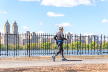 New York, ABD-15 Mayıs, 2019: Jogger New York 'ta Central Park rezervuar boyunca çalışan. Central Park, yıl boyunca aktif insanlarla doludur..