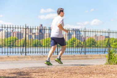 New York, ABD-15 Mayıs, 2019: Jogger New York 'ta Central Park rezervuar boyunca çalışan. Central Park, yıl boyunca aktif insanlarla doludur..