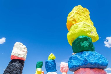 Las Vegas, Nevada, ABD - 12 Mayıs 2019: Las Vegas şehri yakınlarındaki Seven Magic Mountains sanat enstalasyonu. Neon renkli kayalardan yapılmış sütunlar çorak çöl arka plan ve mavi gökyüzüne karşı durmak.