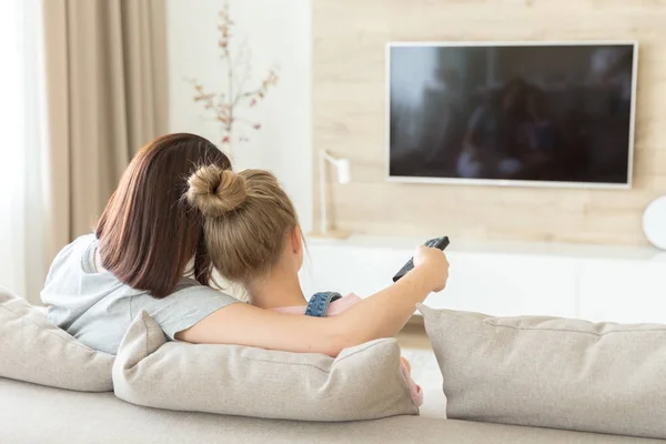 Mutter und Tochter sitzen auf Sofa vor dem Fernseher — Stockfoto