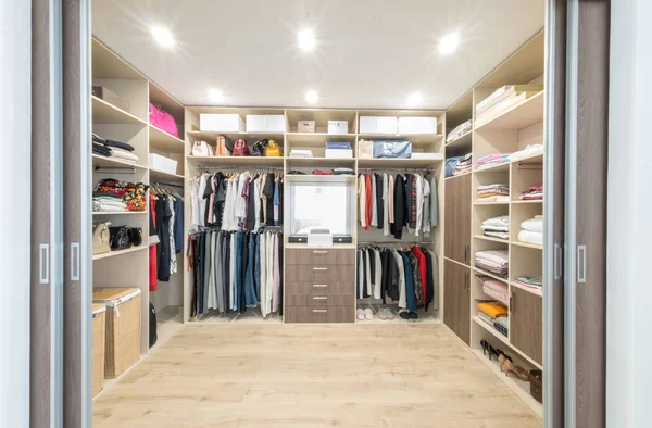 Big wardrobe with different clothes for dressing room