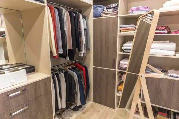 Big wardrobe with different clothes for dressing room