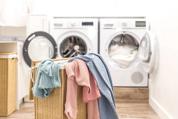 Cesta de lavandería con ropa sucia con lavadoras y secadoras en el fondo — Foto de Stock