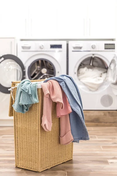 Cesta de lavandería con ropa sucia con lavadoras y secadoras en el fondo — Foto de Stock