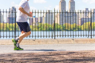 New York, ABD-15 Mayıs, 2019: Jogger New York 'ta Central Park rezervuar boyunca çalışan. Central Park, yıl boyunca aktif insanlarla doludur..
