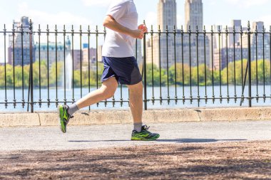 New York, ABD-15 Mayıs, 2019: Jogger New York 'ta Central Park rezervuar boyunca çalışan. Central Park, yıl boyunca aktif insanlarla doludur..