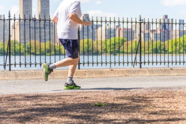 New York, ABD-15 Mayıs, 2019: Jogger New York 'ta Central Park rezervuar boyunca çalışan. Central Park, yıl boyunca aktif insanlarla doludur..
