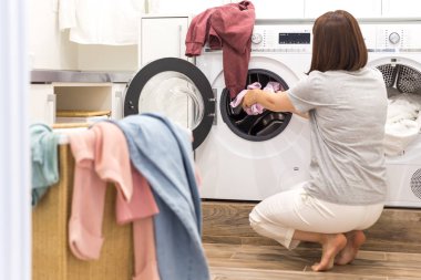 Çamaşır Hanede Çamaşır Makinesi ve Bir Sepet Dolusu Kirli Çamaşır Dolduran Genç Kadın