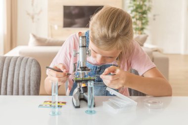 Kız öğrenme Kimya evde mikroskop ile oynuyor