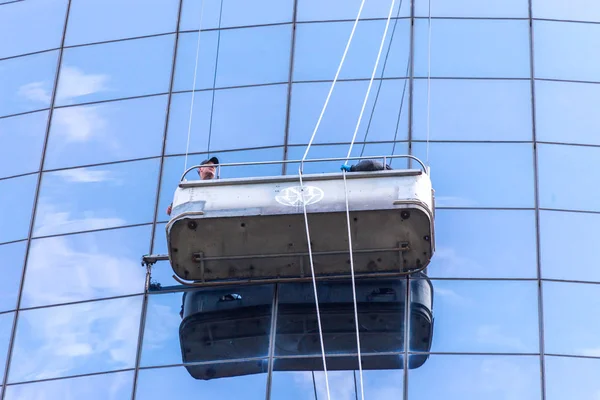 НЬЮ-ЙОРК, США - 16 мая 2019 года: Два уборщика моют окна современного небоскреба — стоковое фото