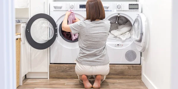 Жінка кладе одяг до пральної машини для прання — стокове фото