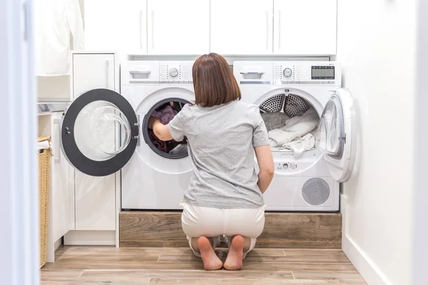 Mujer poniendo ropa a la lavadora para lavar — Foto de Stock