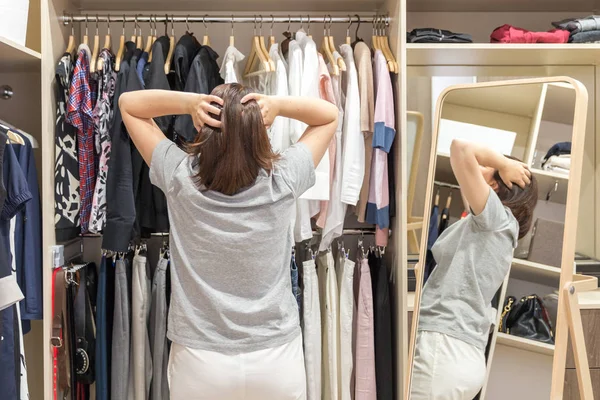 Hermosa chica está eligiendo ropa en su vestidor —  Fotos de Stock