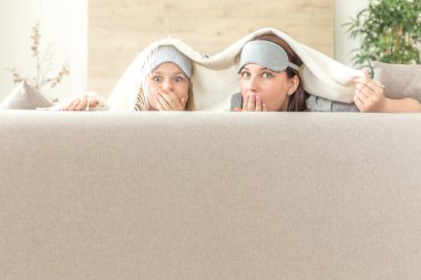 Anne ve kızı happ aile kavramı. uyku maskesi takmak ve oturma odasında kanepede eğlenmek