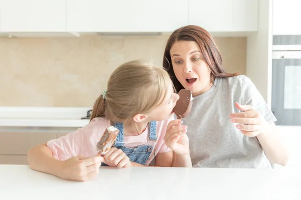 Moeder met dochter in keuken eten ijs. Goede relaties van ouder en kind. Gelukkig familieconcept — Stockfoto