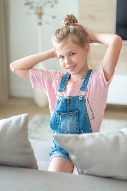 Kanepe üzerinde oturan sarışın ön-genç kız portresi