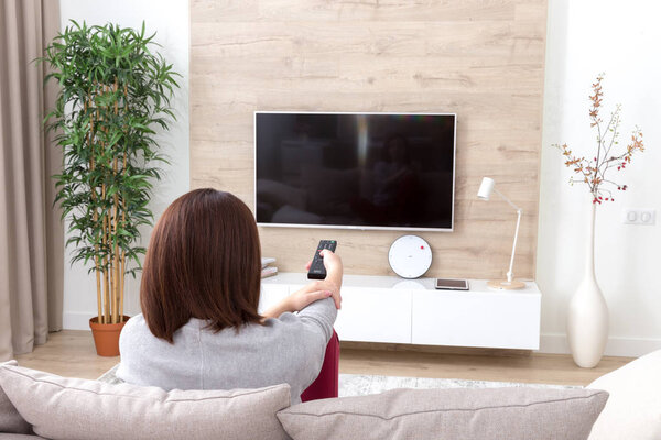 Young woman watching TV in the room