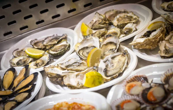 Oysters on plastic plates on seafood market