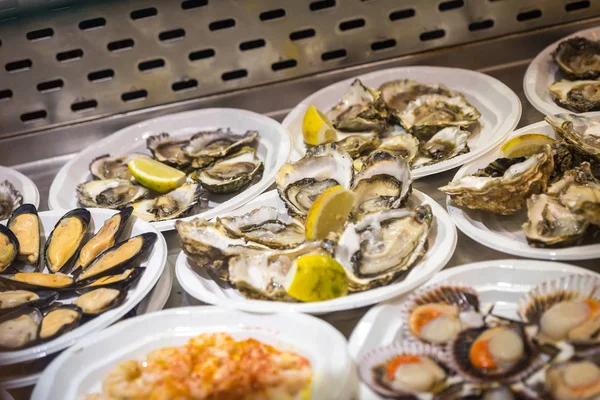 Oysters on plastic plates on seafood market