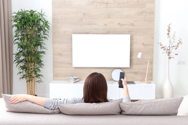 Junge Frau vor dem Fernseher im Zimmer. weißer, leerer Bildschirm für Design — Stockfoto