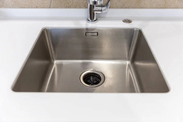 Stainless kitchen sink with food waste disposal in modern home