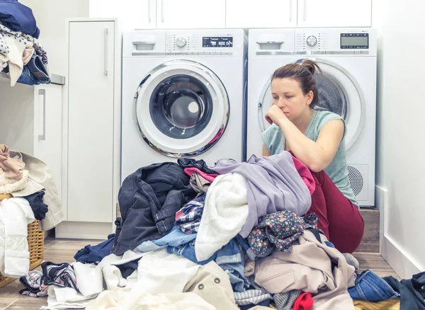 Втомлена нещасна жінка домогосподарка в пральні біля пральної машинки — стокове фото