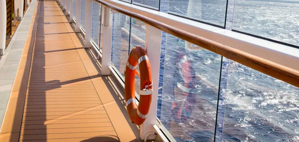Orange reddingsboei op een dek van cruiseschip met Oceaan op de achtergrond met Kopieer ruimte — Stockfoto
