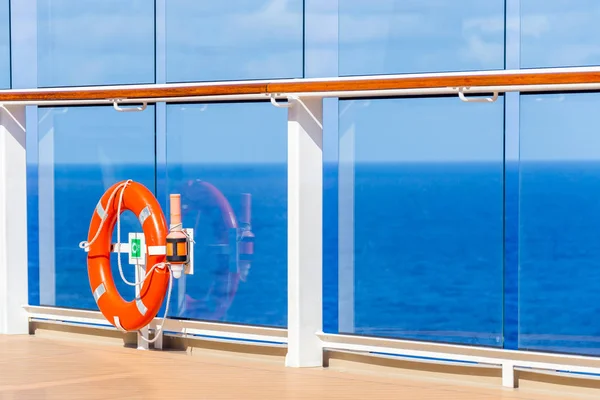 Orange lifebuoy on a deck of cruise ship with ocean on background with copy space — Stock Photo, Image