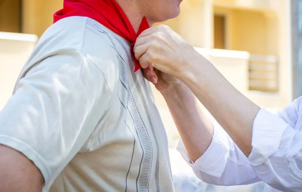 Donna lega il fazzoletto di seta rosso a un uomo — Foto Stock