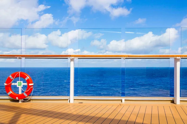 Orange reddingsboei op een dek van cruiseschip met Oceaan op de achtergrond met Kopieer ruimte — Stockfoto