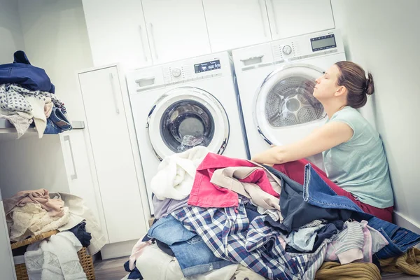 Втомлена нещасна жінка домогосподарка в пральні біля пральної машинки — стокове фото