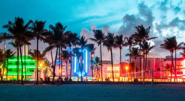 Miami Beach, Abd - 10 Eylül 2019: Ocean Drive otelleri ve restoranları gün batımında. Geceleri palmiye ağaçları ile şehir silueti. Güney sahilinde Art deco gece hayatı