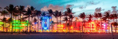 Miami Beach, Abd - 10 Eylül 2019: Ocean Drive otelleri ve restoranları gün batımında. Geceleri palmiye ağaçları ile şehir silueti. Güney sahilinde Art deco gece hayatı