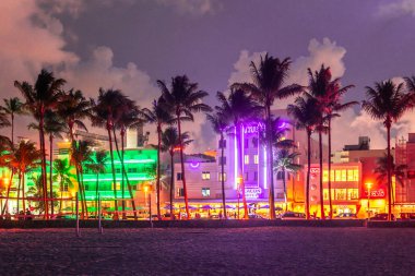 Miami Beach, Abd - 10 Eylül 2019: Gün batımında Miami Beach'te Ocean Drive. Gün batımında palmiye ağaçları ile şehir silueti. Güney sahilinde Art deco